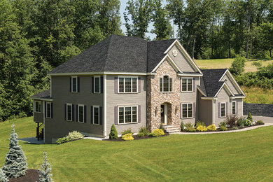 Modelo de fachada beige de estilo americano de tamaño medio de dos plantas con revestimientos combinados y tejado a dos aguas
