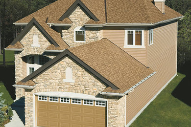 Diseño de fachada de casa beige de estilo americano grande de dos plantas con revestimientos combinados, tejado a cuatro aguas y tejado de teja de madera