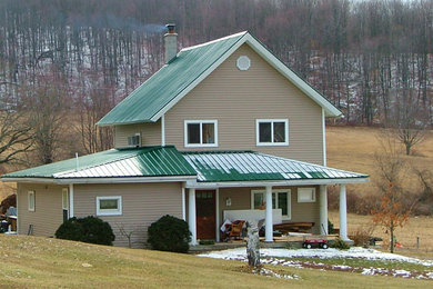 Imagen de fachada de casa marrón clásica de tamaño medio de dos plantas con revestimiento de aglomerado de cemento, tejado a dos aguas y tejado de metal