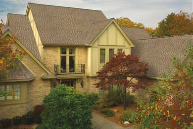 Foto de fachada beige clásica de tamaño medio de dos plantas con revestimiento de ladrillo y tejado a dos aguas