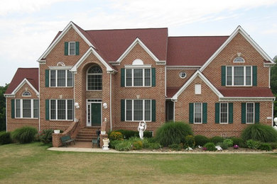 Large and red traditional two floor brick house exterior in Baltimore with a hip roof.