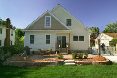 Exemple d'une façade de maison jaune chic en bois de taille moyenne et de plain-pied avec un toit à deux pans.