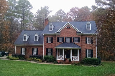 Example of a large classic two-story brick exterior home design in Raleigh