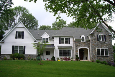 Пример оригинального дизайна: двухэтажный, белый частный загородный дом в классическом стиле с комбинированной облицовкой и двускатной крышей