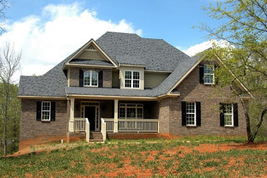 Diseño de fachada de casa roja tradicional grande a niveles con revestimientos combinados, tejado a doble faldón y tejado de teja de madera