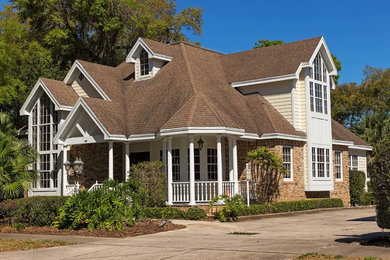 Ejemplo de fachada de casa clásica grande de dos plantas con tejado de teja de madera