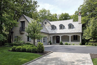 Example of a mid-sized french country beige two-story exterior home design in Minneapolis with a shingle roof