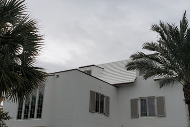 Modelo de fachada de casa blanca minimalista de tamaño medio de tres plantas con revestimiento de aglomerado de cemento, tejado a doble faldón y tejado de teja de madera