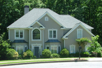 Mid-sized transitional gray two-story stucco house exterior idea in Atlanta with a hip roof and a shingle roof