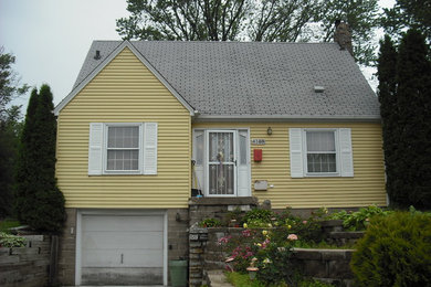 Exemple d'une façade de maison jaune en bois de taille moyenne et à un étage.