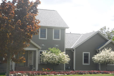 Foto de fachada de casa gris clásica de tamaño medio de dos plantas con revestimientos combinados y tejado a dos aguas