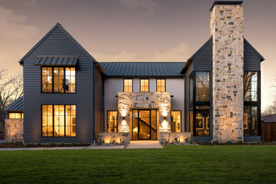 Diseño de fachada de casa multicolor campestre de dos plantas con revestimientos combinados, tejado a dos aguas y tejado de metal