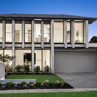 Photo of a large contemporary two-storey concrete grey house exterior in Melbourne with a hip roof and a shingle roof.