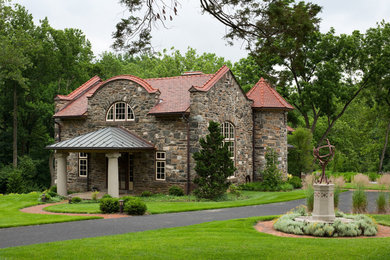 Ejemplo de fachada marrón clásica de tamaño medio de dos plantas con revestimiento de piedra y tejado a dos aguas