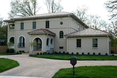 Inspiration for a large mediterranean beige three-story brick exterior home remodel in DC Metro with a hip roof