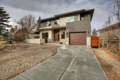 Example of a mid-sized trendy brown two-story stucco exterior home design in Calgary with a hip roof