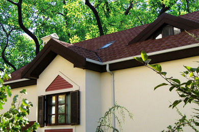 Diseño de fachada beige tradicional de tamaño medio de dos plantas con tejado plano
