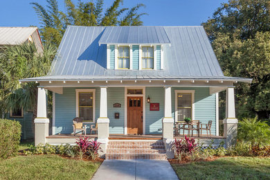 Large arts and crafts blue two-story wood exterior home photo in Tampa with a shed roof