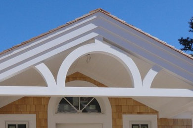 Ejemplo de fachada blanca costera de tamaño medio de una planta con revestimiento de madera y tejado a dos aguas
