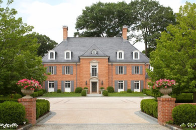 Example of a huge classic three-story brick house exterior design in New York with a hip roof and a shingle roof