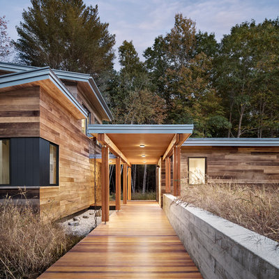 Large trendy brown one-story wood house exterior photo in Portland Maine