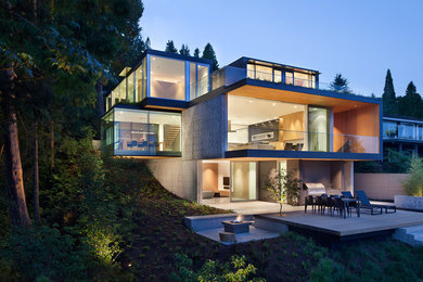 Diseño de fachada minimalista de tres plantas con revestimiento de hormigón y tejado plano