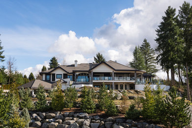 This is an example of an expansive and gey rustic detached house in Vancouver with three floors, mixed cladding, a pitched roof and a shingle roof.