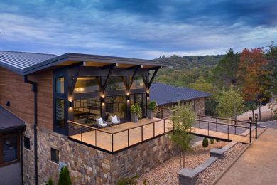 Inspiration for a large contemporary brown three-story wood house exterior remodel in Other with a butterfly roof, a metal roof and a brown roof