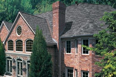 Inspiration for a large timeless red two-story brick exterior home remodel in Atlanta with a shingle roof