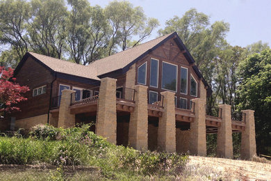 Foto de fachada marrón rústica de tamaño medio de dos plantas con revestimiento de madera y tejado a dos aguas