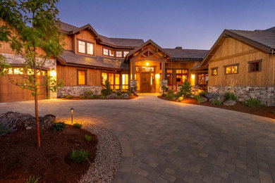Large mountain style brown two-story wood exterior home photo in Other