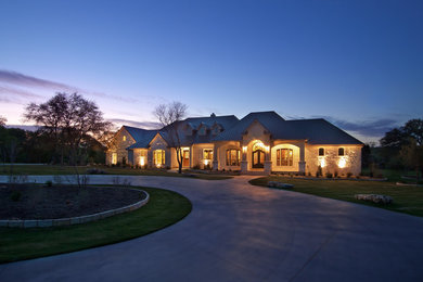 Example of a huge classic beige two-story stone exterior home design in Austin