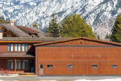 Идея дизайна: двухэтажный, коричневый дом среднего размера в стиле рустика с комбинированной облицовкой и двускатной крышей