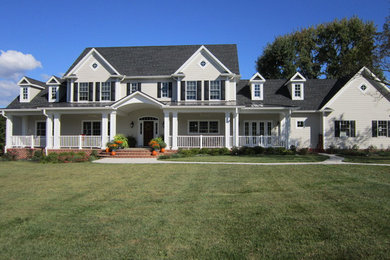 Imagen de fachada blanca clásica de dos plantas con revestimiento de aglomerado de cemento y tejado a dos aguas