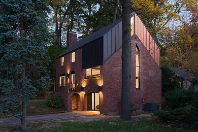 Imagen de fachada minimalista de tres plantas con revestimiento de metal y tejado a dos aguas