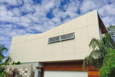 Foto de fachada blanca moderna de tamaño medio de dos plantas con revestimiento de aglomerado de cemento