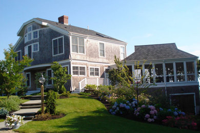Example of a mid-sized trendy gray three-story wood house exterior design in Boston with a clipped gable roof and a shingle roof