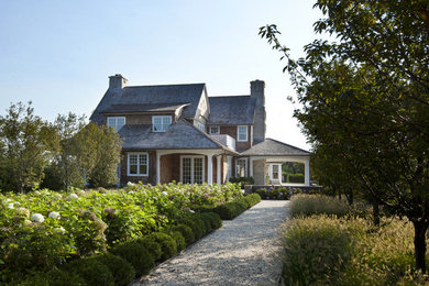 Diseño de fachada de casa marrón costera de tamaño medio de dos plantas con revestimiento de madera, tejado a dos aguas y tejado de teja de madera