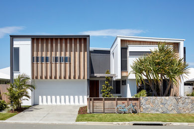 Imagen de fachada de casa multicolor actual de dos plantas con revestimientos combinados y tejado de un solo tendido