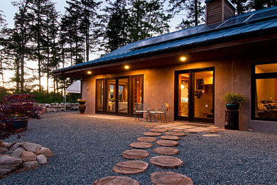 Inspiration for a large rustic brown one-story concrete exterior home remodel in Vancouver with a metal roof