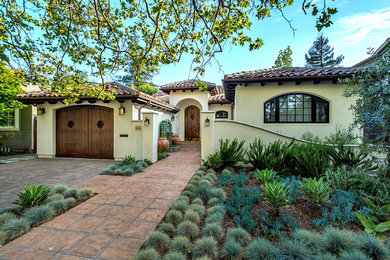 Inspiration for a mediterranean beige one-story house exterior remodel in San Francisco with a hip roof and a tile roof