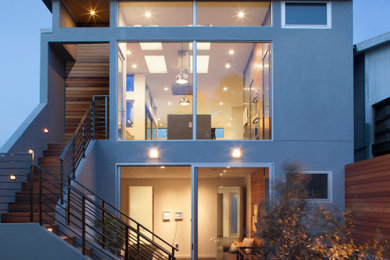 Foto de fachada de casa gris actual de tamaño medio de dos plantas con revestimiento de estuco y tejado plano