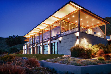 Inspiration pour une grande façade de maison grise minimaliste en pierre à deux étages et plus avec un toit plat.