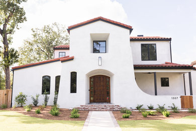 Example of a tuscan white two-story stucco house exterior design in Jacksonville with a tile roof