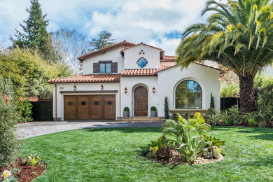 Large tuscan white two-story stucco exterior home photo in San Francisco with a tile roof