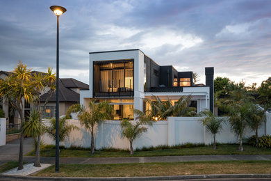 Foto de fachada de casa blanca grande de dos plantas con revestimiento de ladrillo, tejado plano y tejado de teja de barro