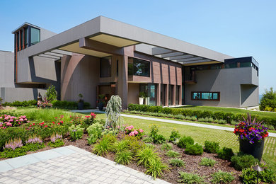 Imagen de fachada de casa marrón contemporánea grande de una planta con tejado plano y revestimiento de aglomerado de cemento