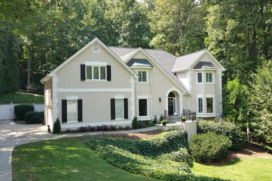Large transitional beige two-story stucco house exterior idea in Atlanta with a hip roof and a shingle roof