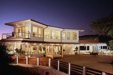 Immagine della facciata di una casa stile marinaro a due piani di medie dimensioni con tetto piano