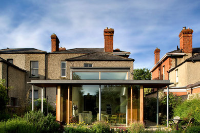Exempel på ett modernt brunt hus, med valmat tak